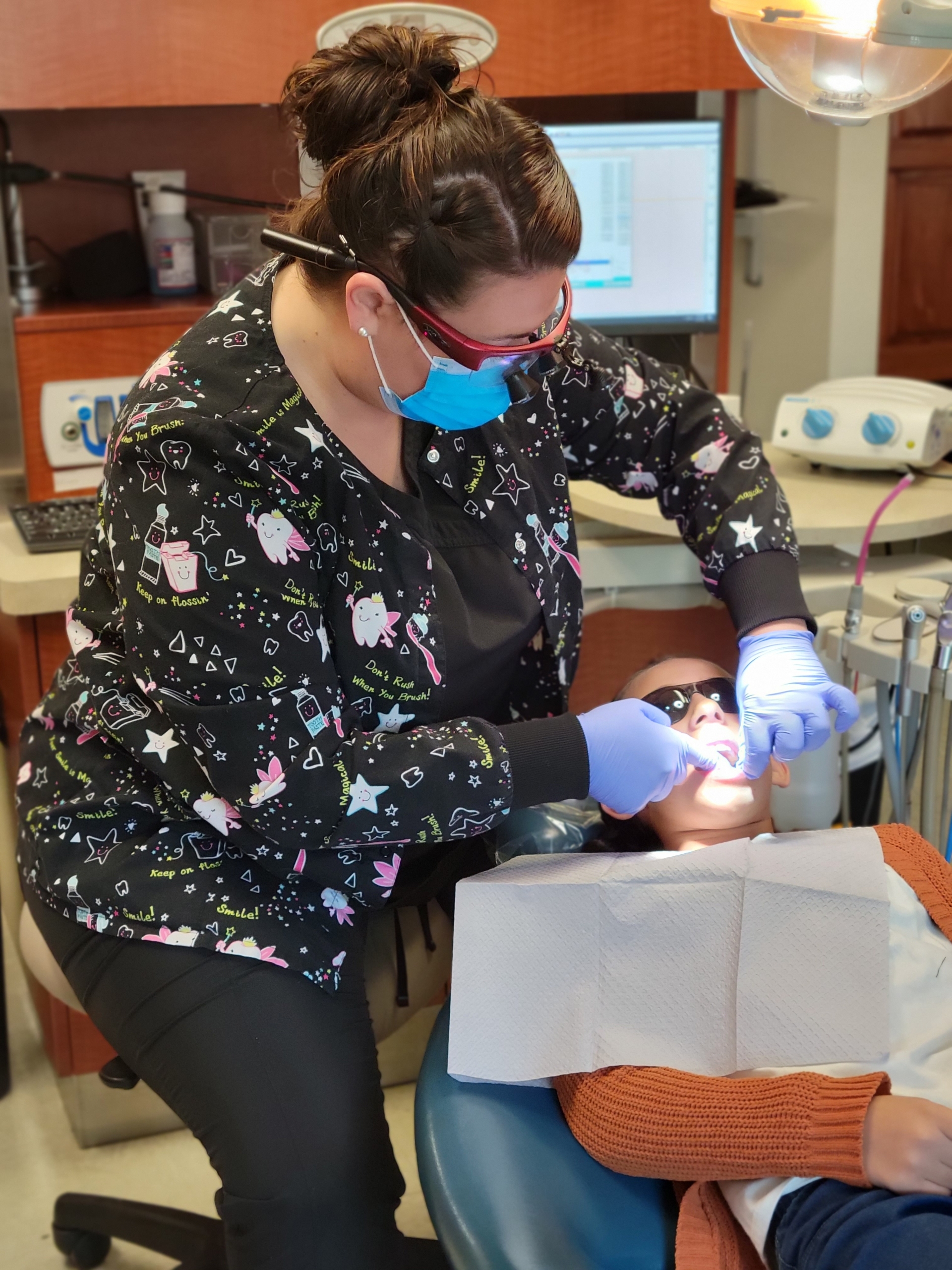 Dental hygienist flossing patient's teeth