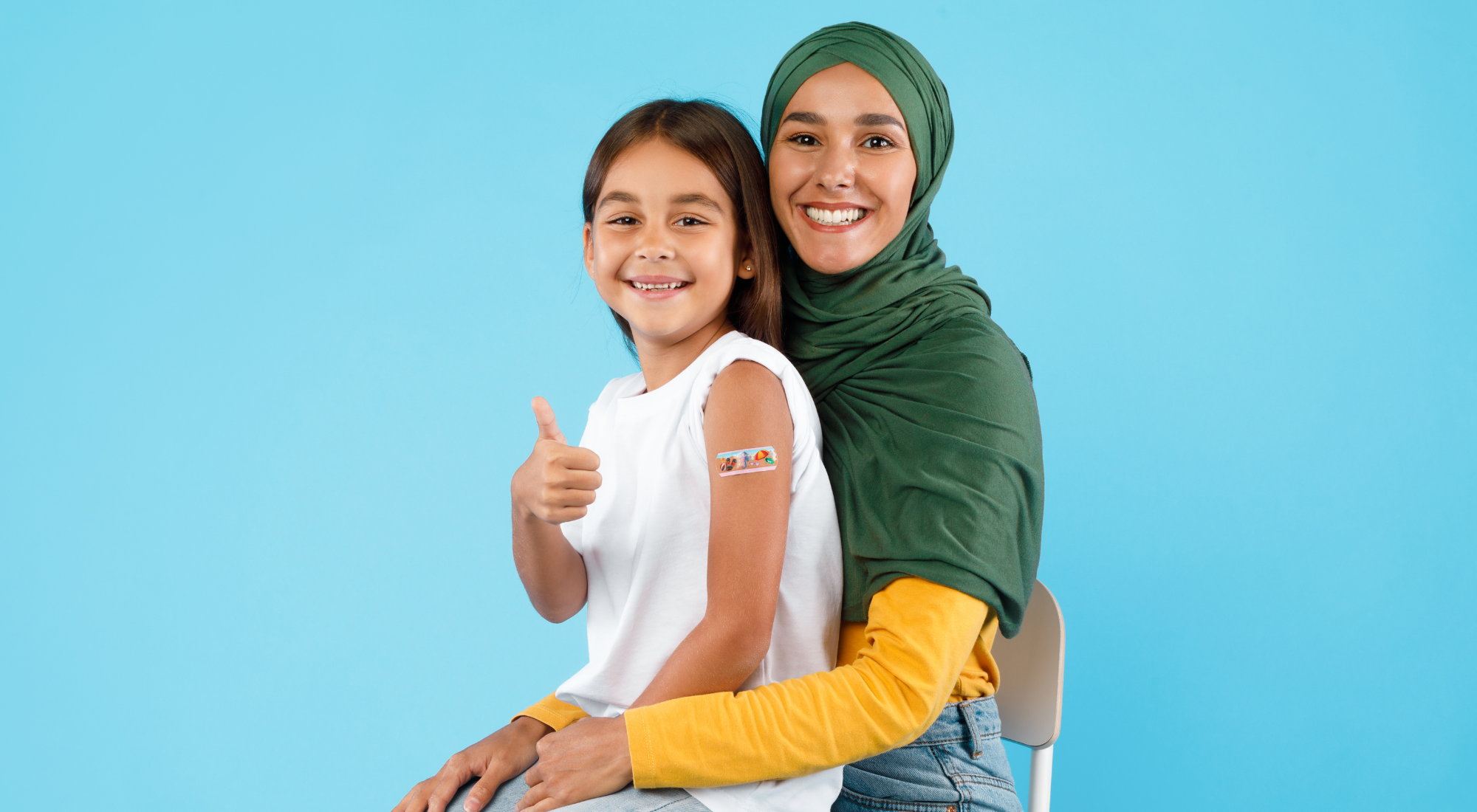 child on mother's lap giving thumbs up after vaccine